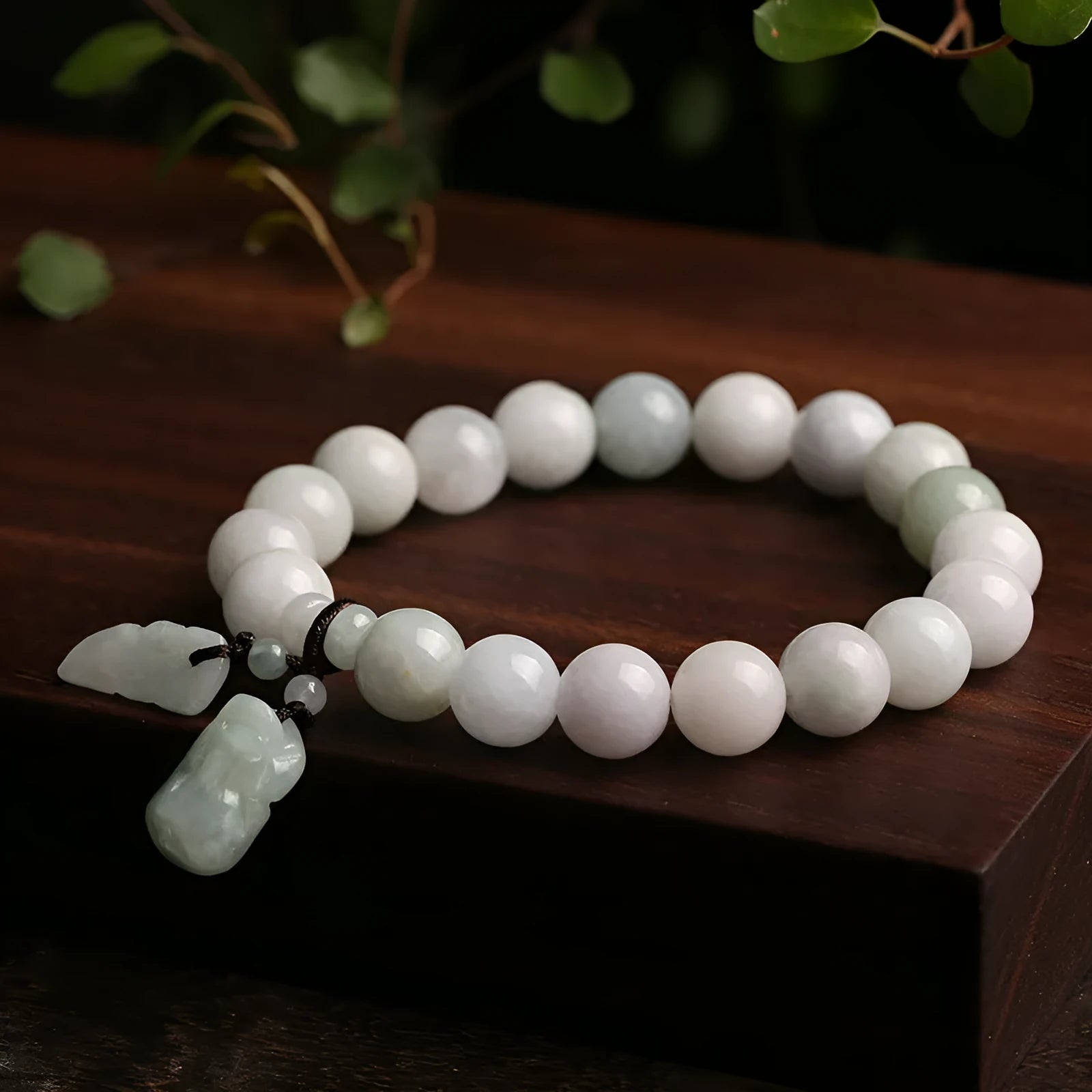 Emerald green jade bracelet with hanging symbolic charms including Maitreya Buddha design