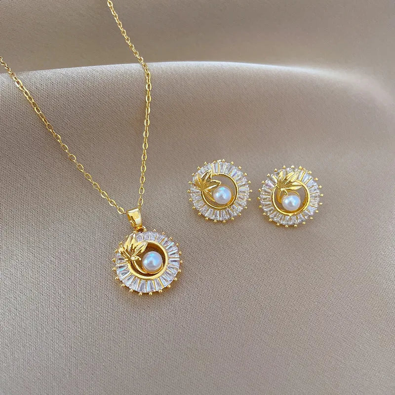 Square geometric necklace with diamond and leaf design alongside matching stud earrings