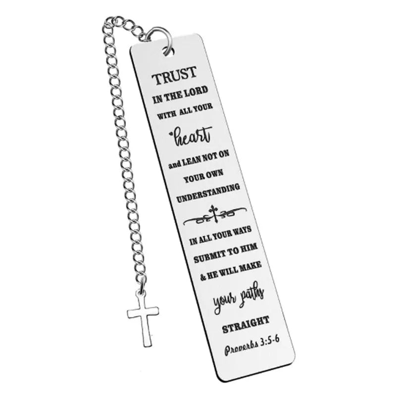 A polished stainless steel bookmark with an engraved inspirational verse, shown against an open book.
