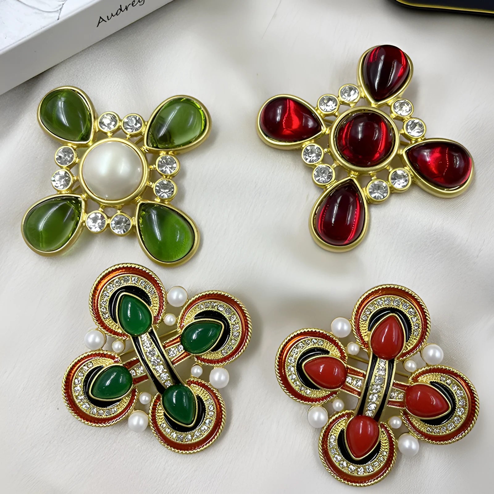 Close-up of a detailed baroque cross brooch with crystal accents on a zinc alloy base.