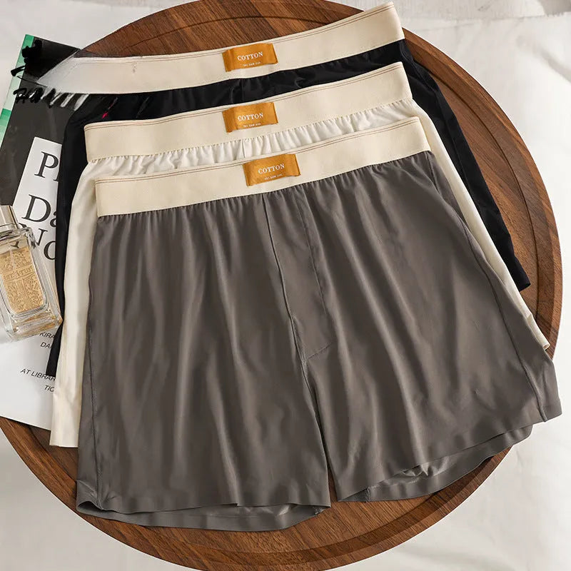 Pack of three pairs of men's solid colour ice silk underwear on a white background.