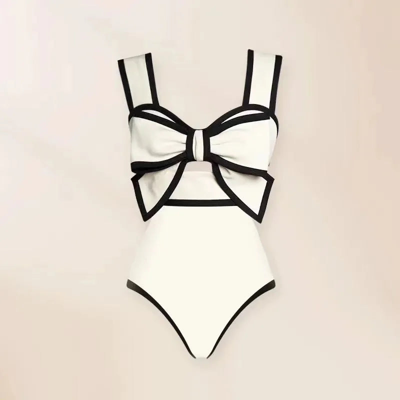 Women's black one-piece swimsuit with white round skirt and bow detail for beach and swimming