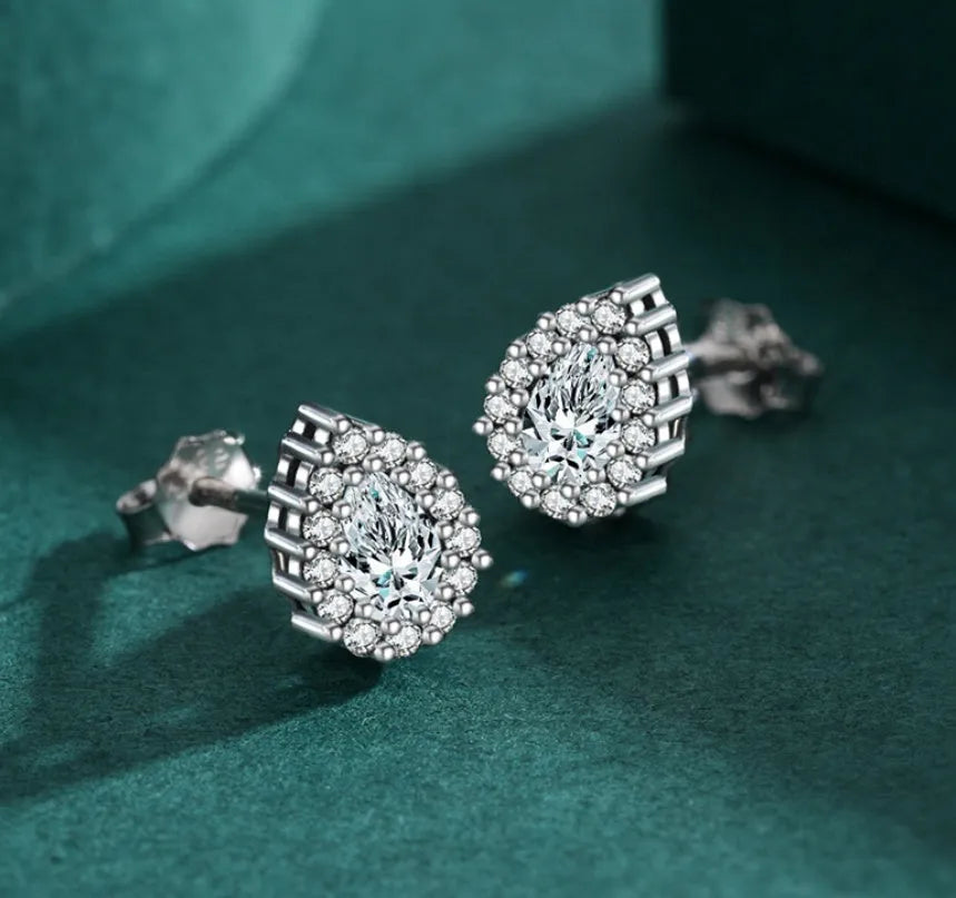 A pair of women's sterling silver water drop shaped stud earrings with a diamond-cut finish.