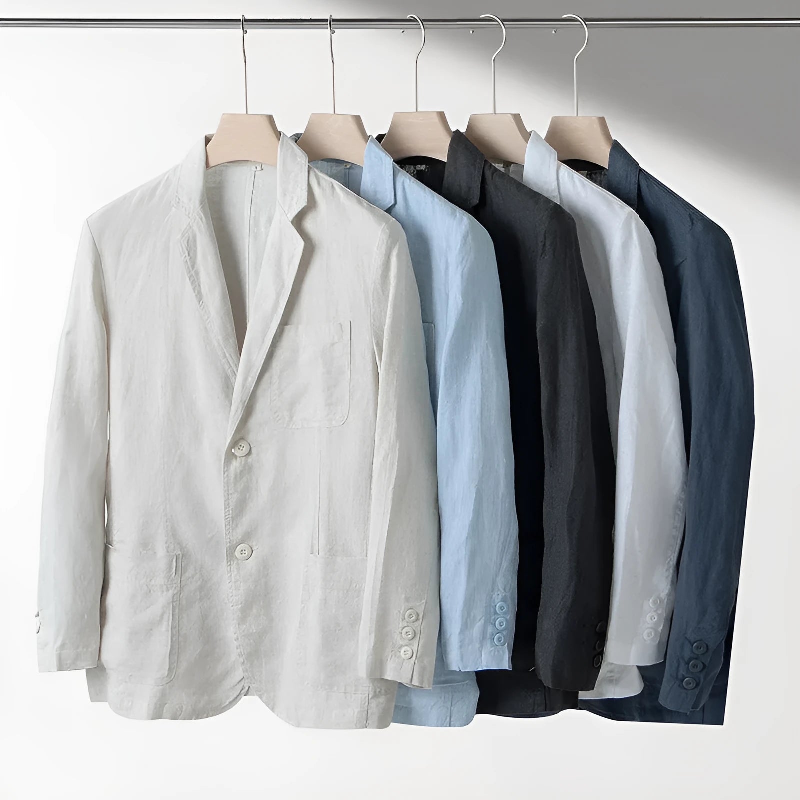 Men's loose fit linen suit jacket in a solid colour on a hanger, showing casual long sleeve design.
