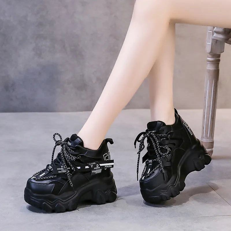 Women's white and black mesh platform sports shoes with cross-strap and rubber sole.