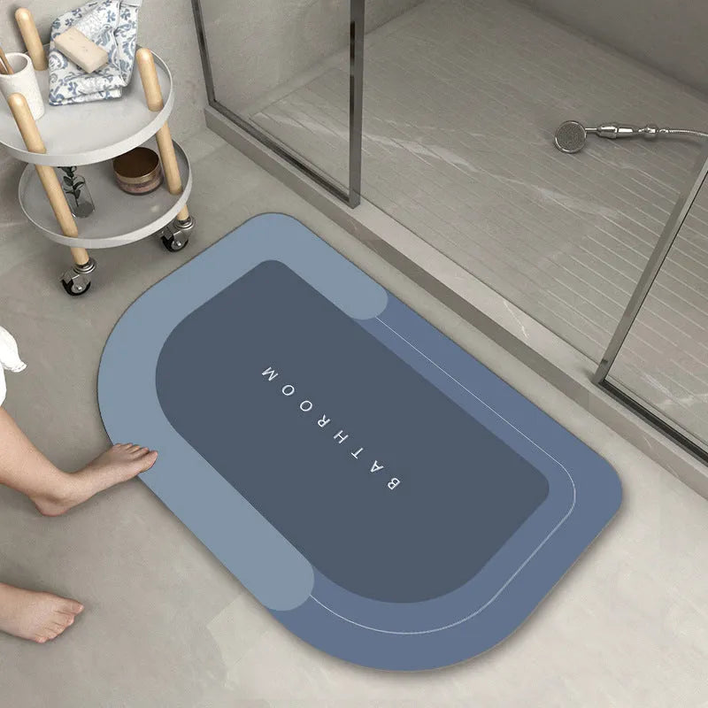 Blended fabric bathroom floor mat in blue colour, shown in an oval shape on a tiled floor.