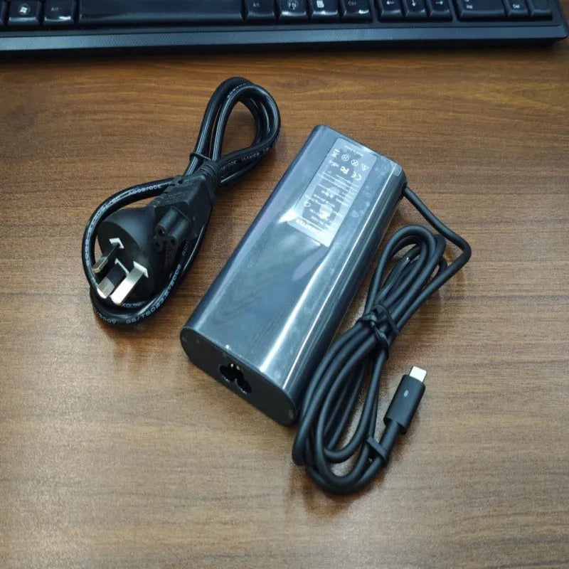 Black 65W Type-C laptop power adapter with a set of interchangeable international plug heads.