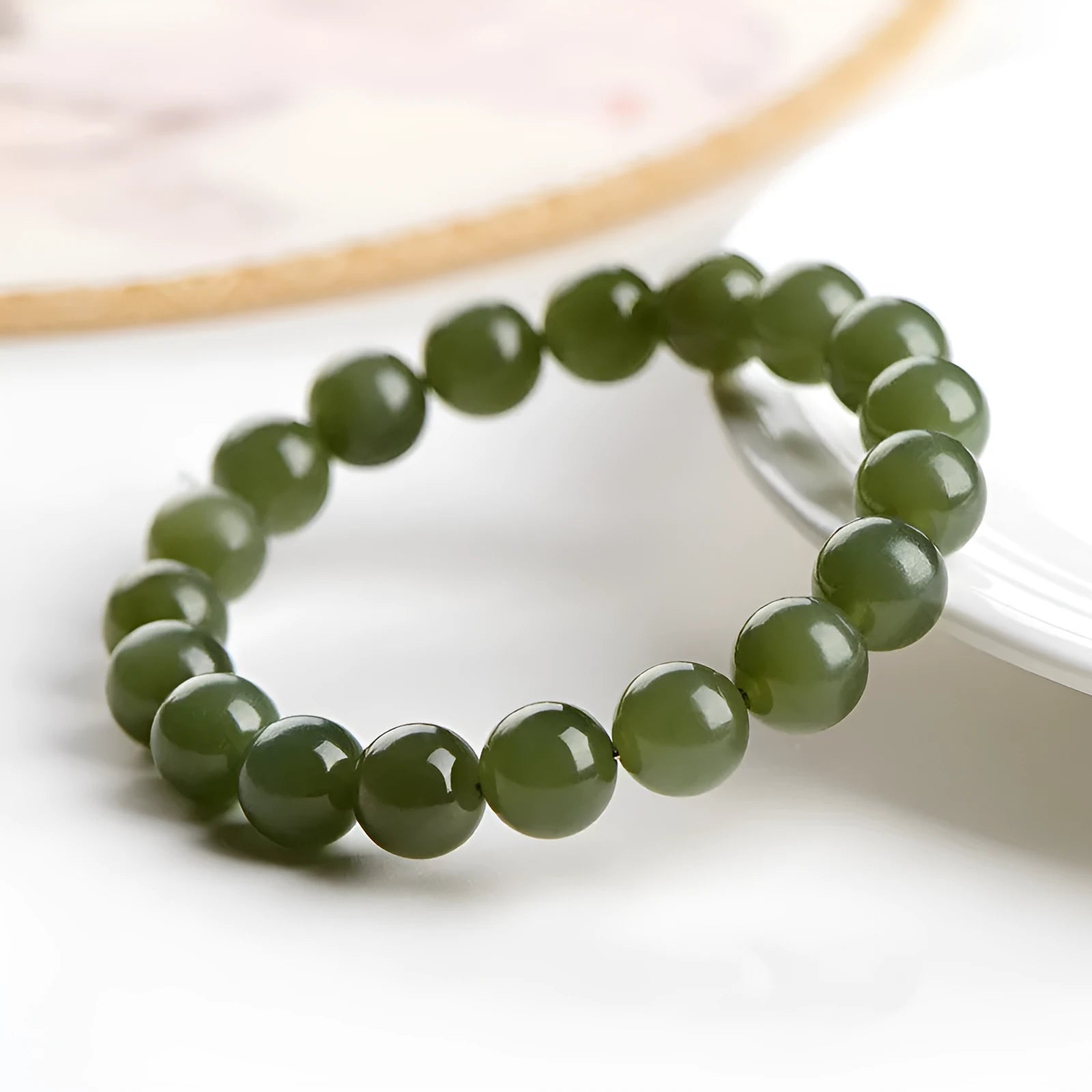 Hetian jade ball bracelet with polished spherical beads on a string, shown in deep and light clear water colour options.