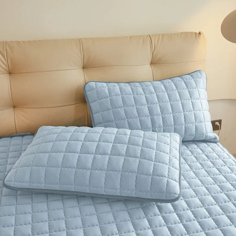 Washed cotton waterproof fitted sheet in light grey colour with elasticated corners on a mattress