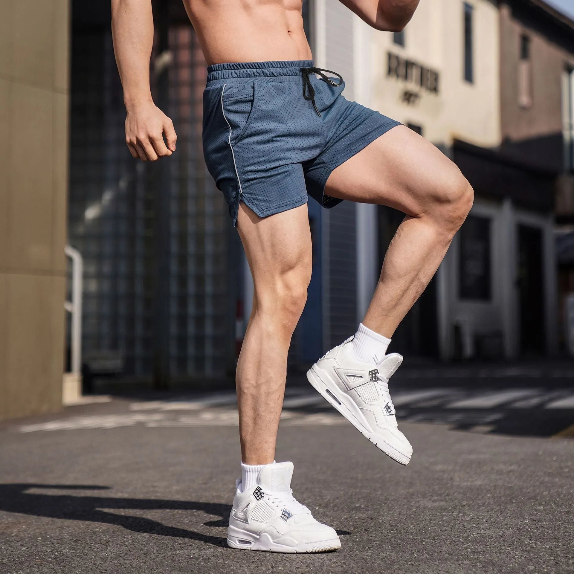 Men's black polyester straight-leg fitness shorts laid flat, showing sports style.