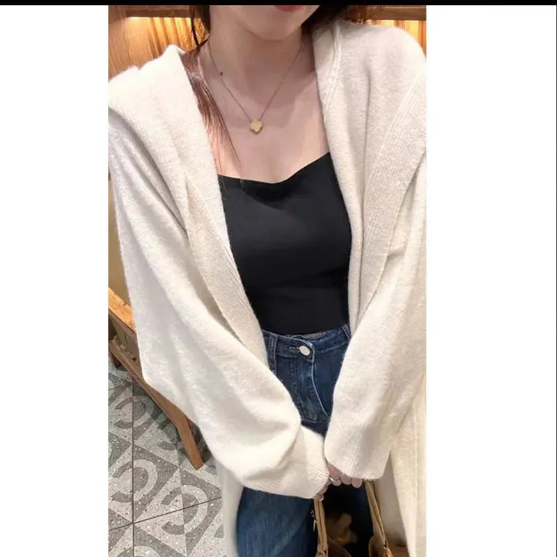 Long grey hooded knitted cardigan on a hanger showing its below-the-knee length and loose fit.