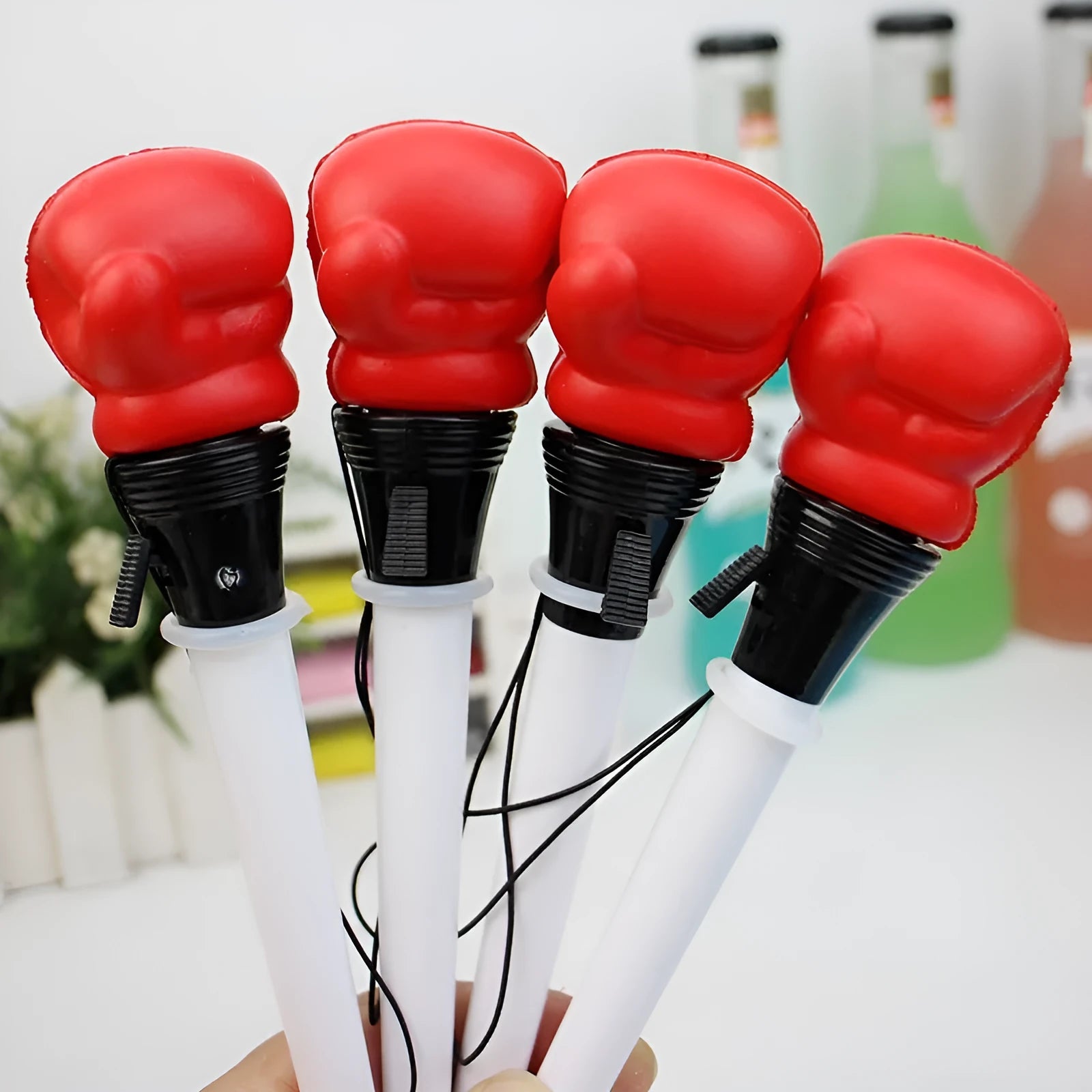 Set of four black ejection pens with a pressure relief boxing press button on the barrel.