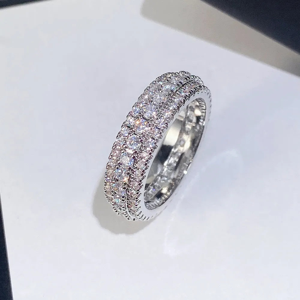 Geometric gang drill style engagement ring with a triangular zircon stone inlay on a metal band.