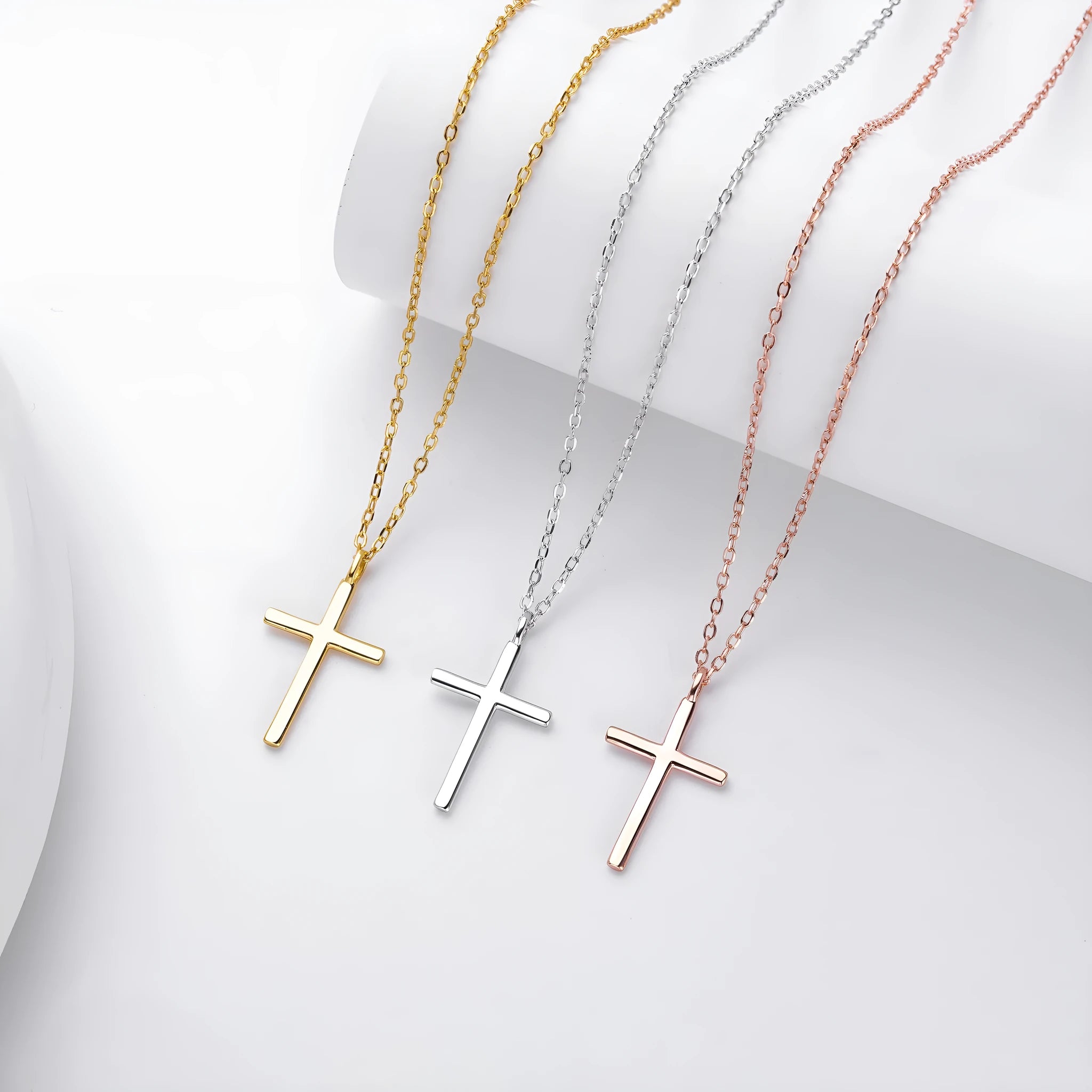 Sterling silver cross necklace with O-shaped chain in gold plating on display