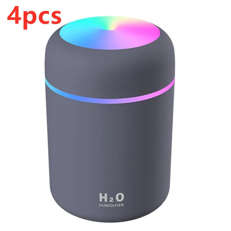 Pink USB portable humidifier with 300ml water tank on wooden desk surface