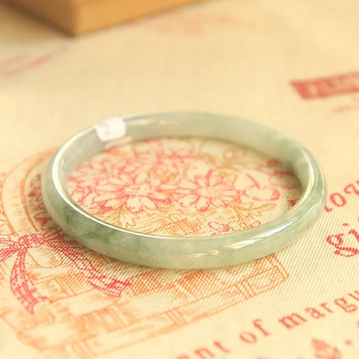 Green jade waxy geometric bracelet with unisex Chinese style design on a wrist.