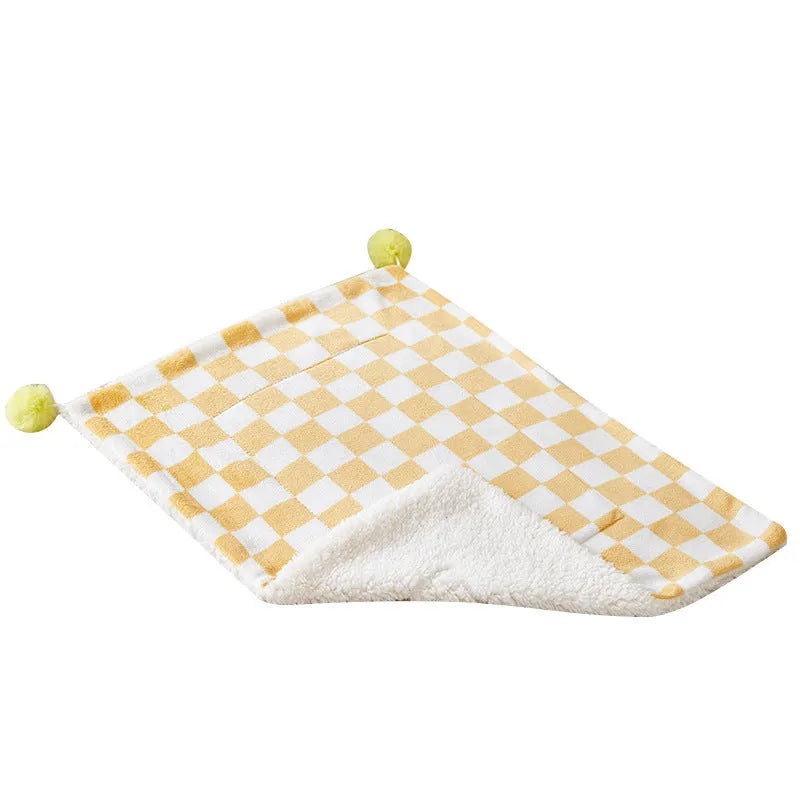 Green plaid pattern pet blanket with soft fleece texture on sofa