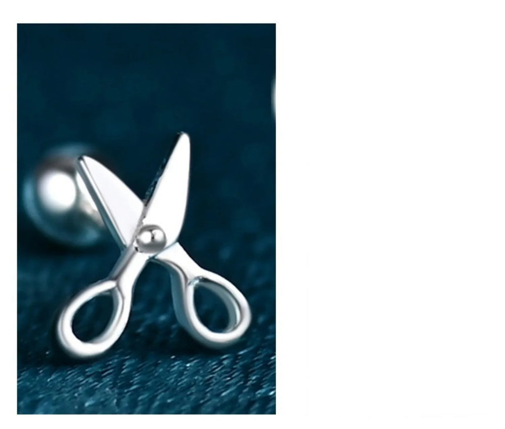 Silver screw-back ear nail with a small scissor charm for cartilage piercing.