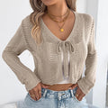 Women's khaki casual coat with lace-up front and hollow-out long sleeves on a hanger.