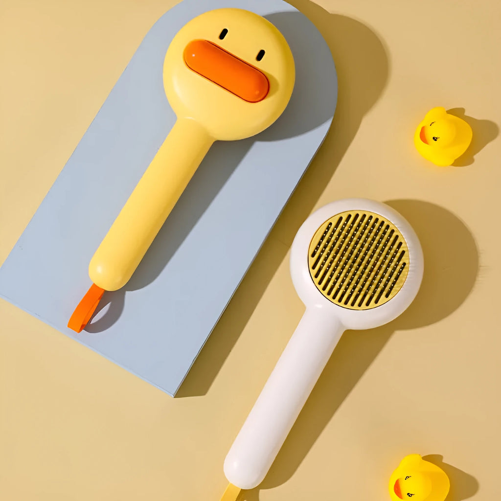 Small yellow duck-shaped pet comb with open sections and floating needles for cat and dog hair removal