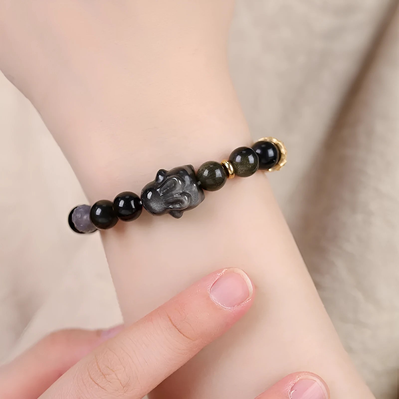 Handmade lying rabbit obsidian bracelet in brass with grey agate, showing national style design.