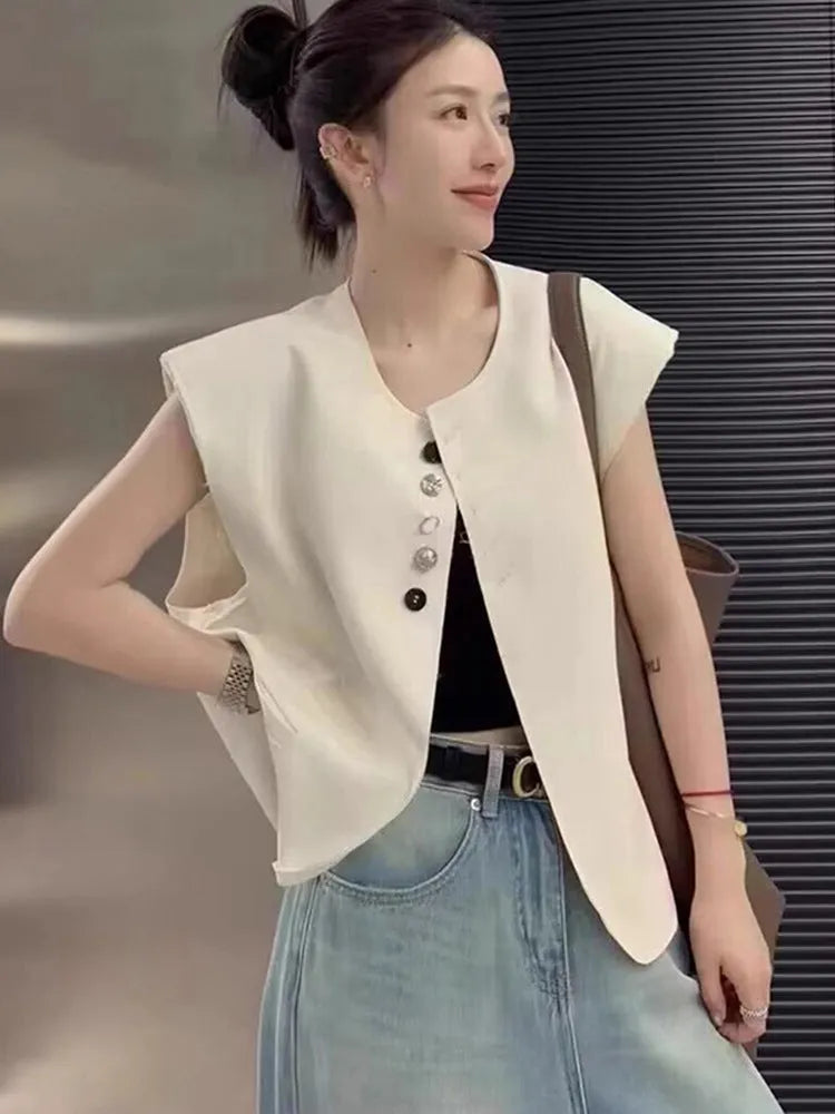 Women's loose-fit short-length polyester vest in milky white colour with front pockets.