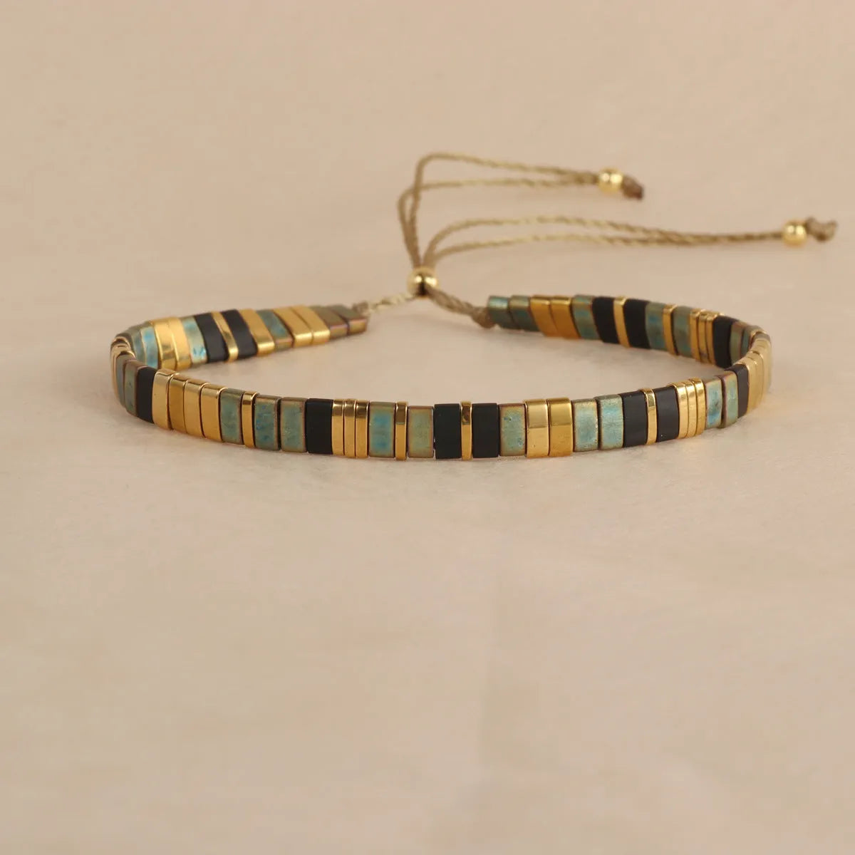 Adjustable pull beads bracelet with glass and coloured glaze beads in geometric and round shapes