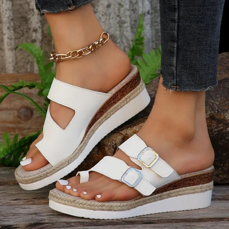 White women's wedge sandals with woven patent leather upper, peep toe, and finger-fit design on a rubber sole.