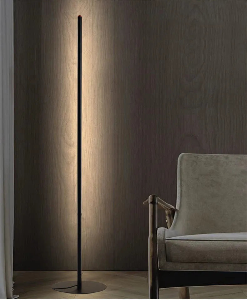 Simple modern vertical aluminium alloy floor lamp in silver, shown beside a sofa.