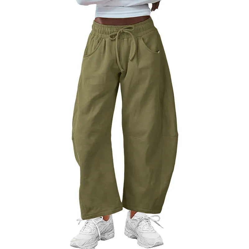 Women's loose grey cropped sweatpants with drawstring waist and side pockets on a hanger.