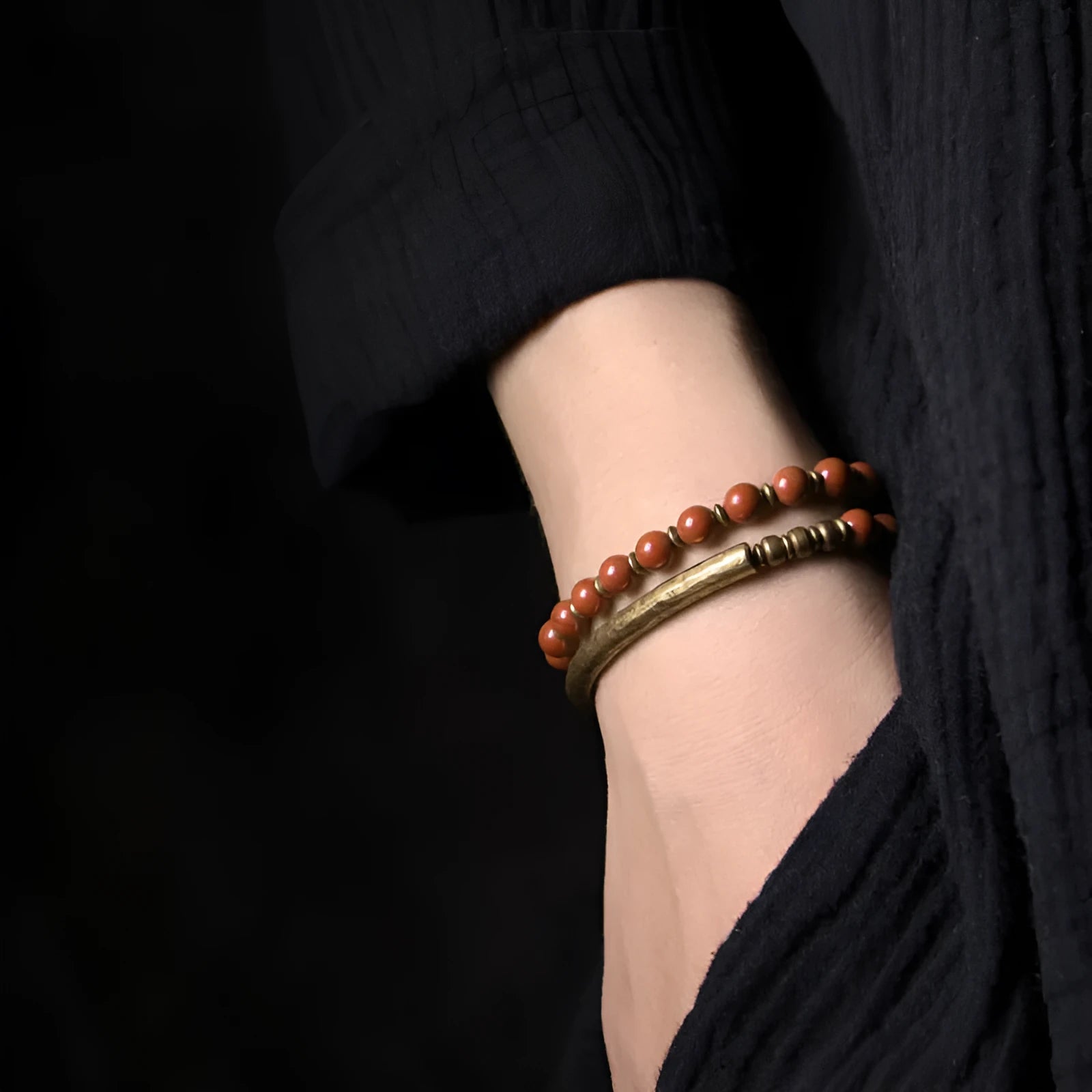Layered ethnic bracelet with natural agate stones and brass charms on wrist