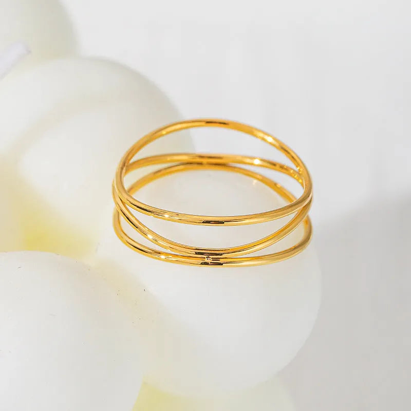 Gold geometric titanium steel ring with three-layer coil design on size chart showing options 5 to 10.