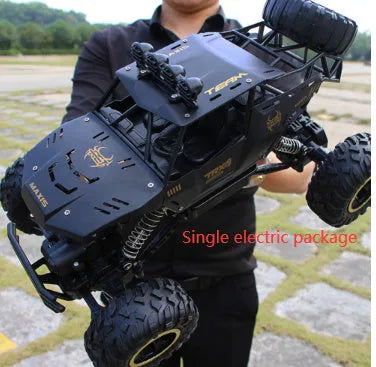 Large black or silver 4WD remote control climbing car on off-road terrain with wireless remote.