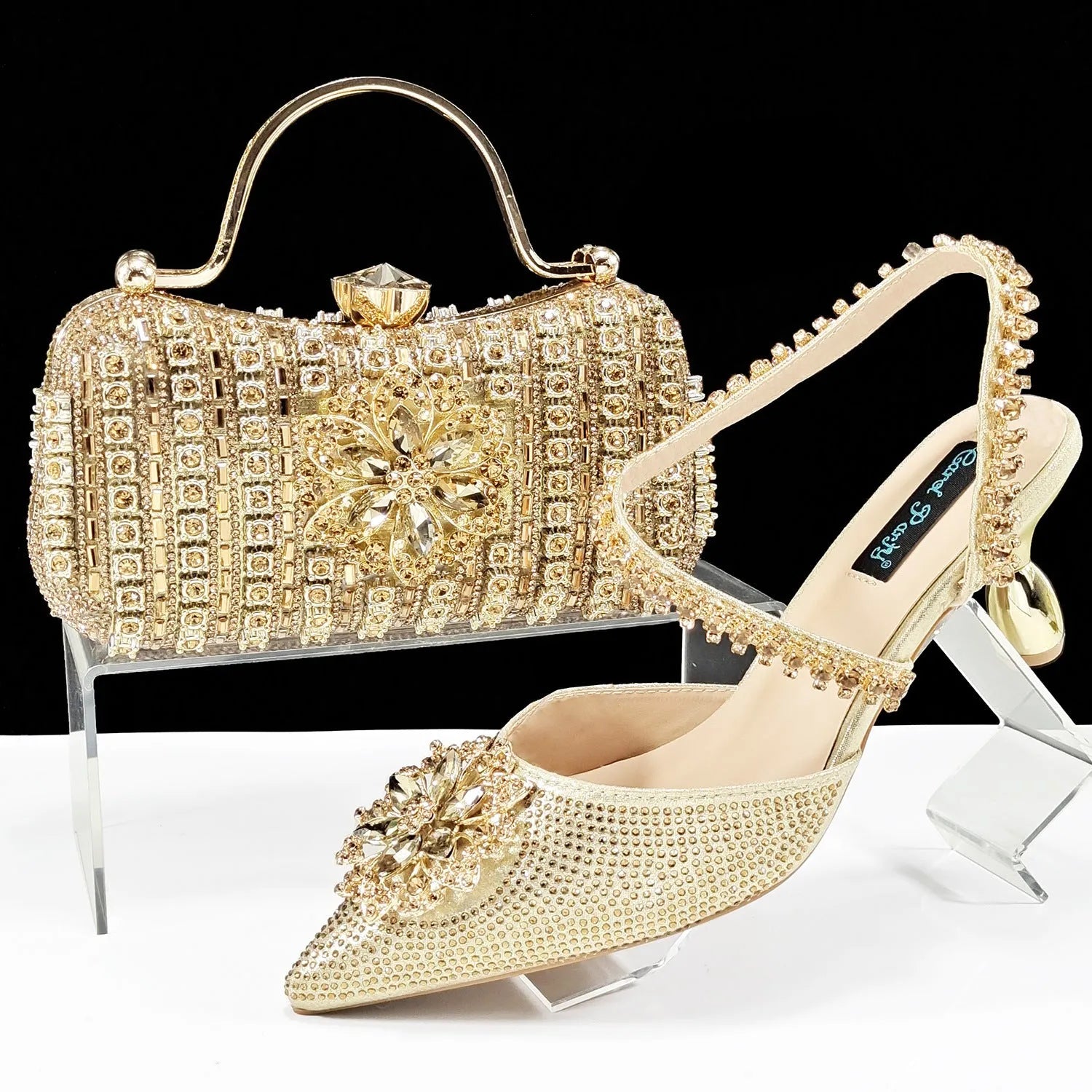 Women's black synthetic leather high-heel shoes with rhinestone ankle chain and matching hard clutch bag.