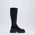 Women's black high leg stretch boots with round toe, non-slip rubber sole, and mid heel on a clean background.