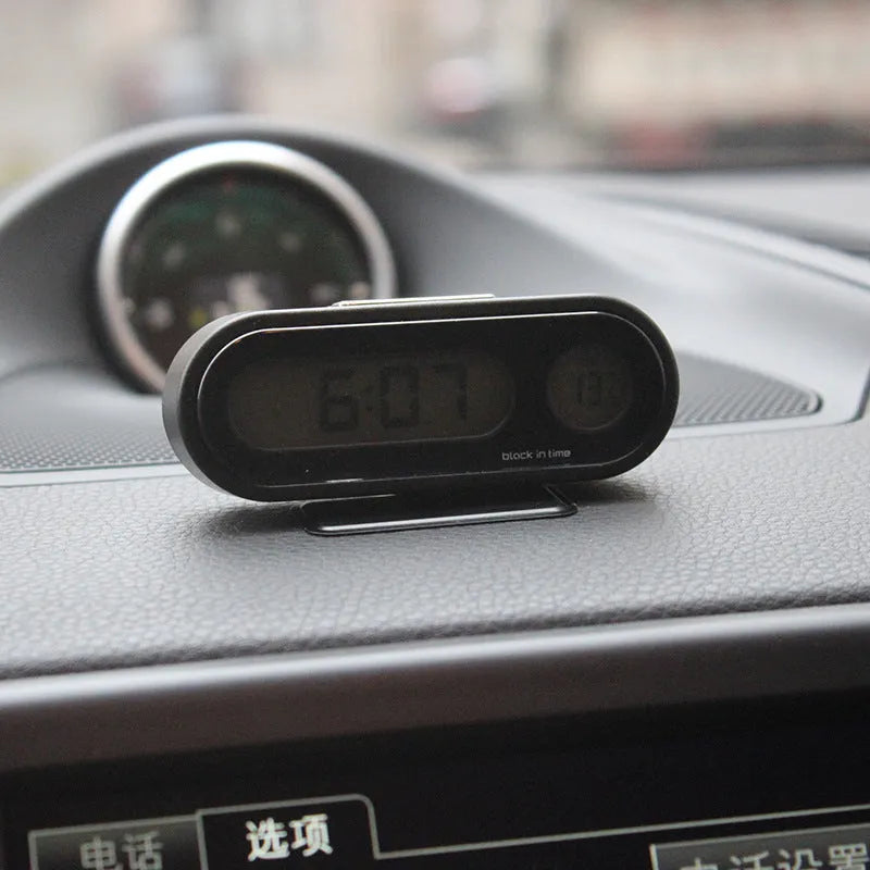 Black electronic car dashboard clock with LED display showing time and temperature