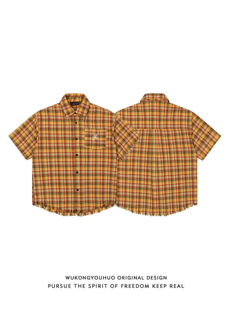Yellow and white plaid short sleeve shirt with embroidered chest pocket on a hanger.