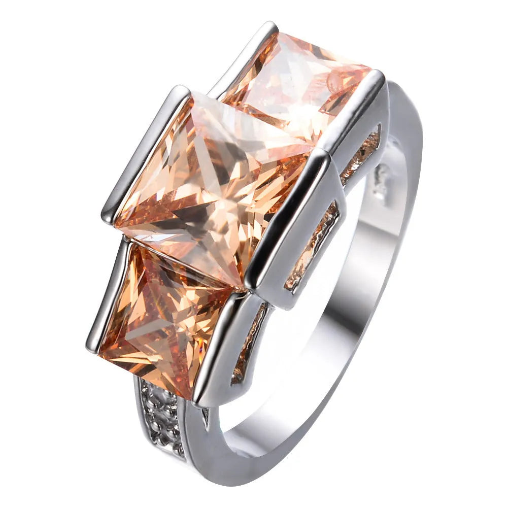 Geometric copper ring for women in champagne colour on a grey background, showing size 8.