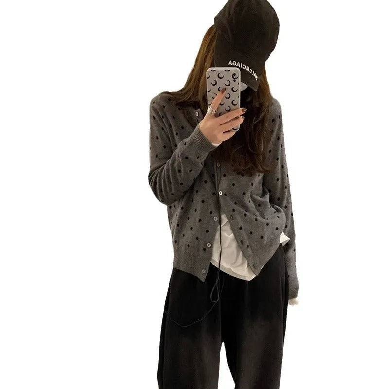Grey dot knitted women's cardigan with crocheted flower details on the front.