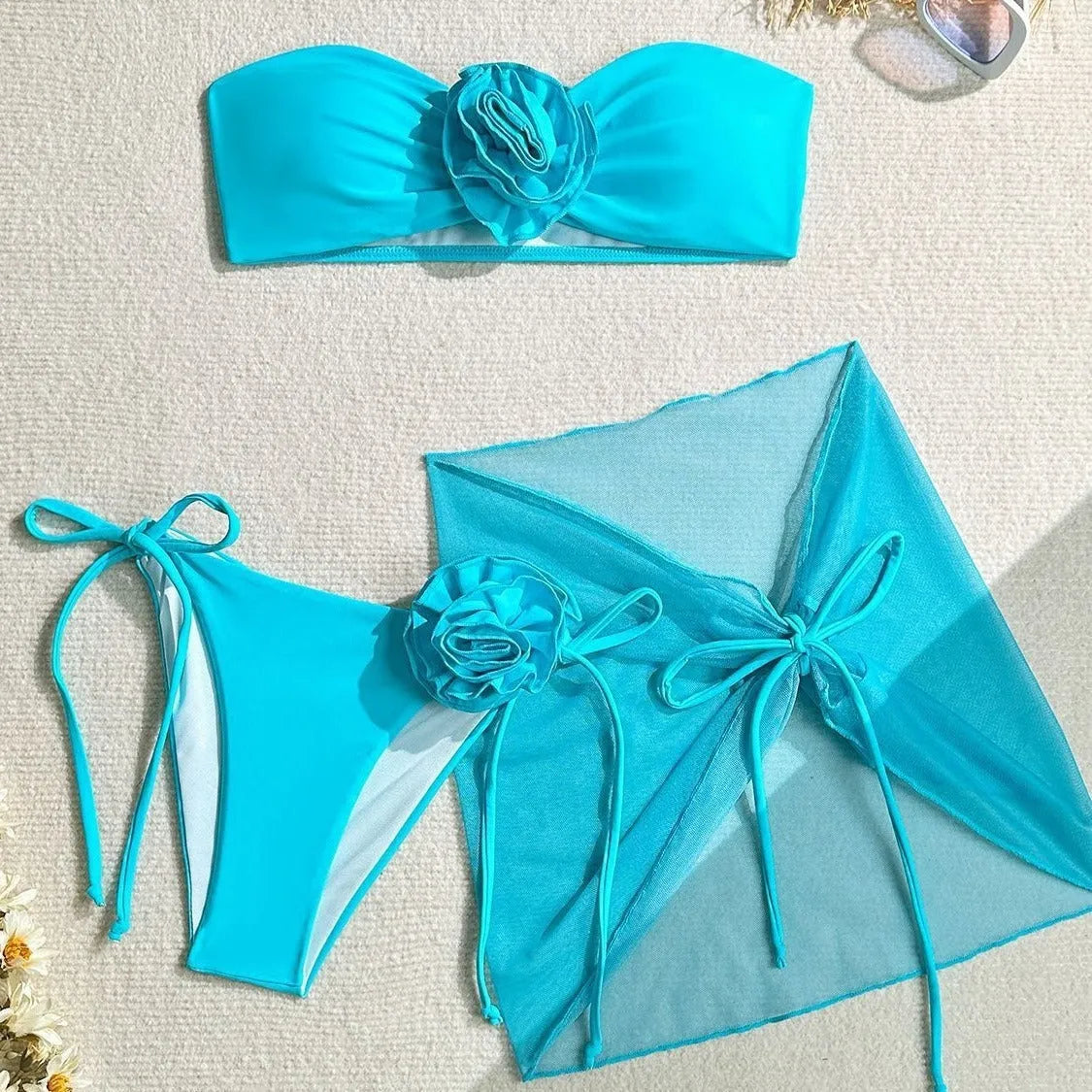 Blue women's tube top swimsuit with big 3D flower tie, matching bottoms, and skirt
