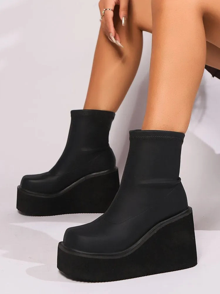 Black plus size women's ankle boots with a wedge heel and round toe on a waterproof platform sole.