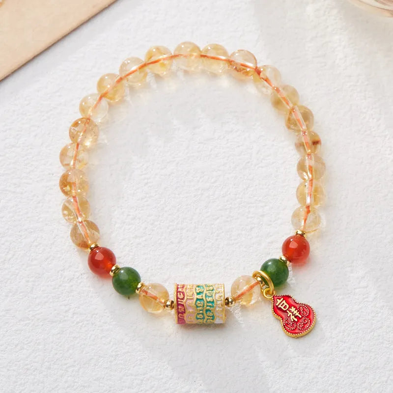 Close-up of a hand-woven citrine five sutra bracelet with 6mm geometric beads on a wrist.