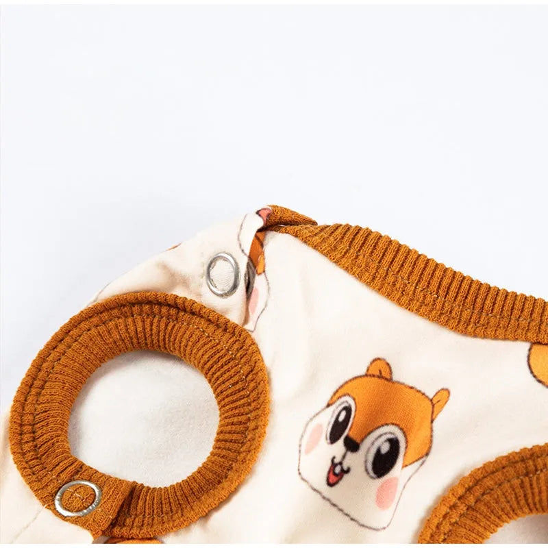 Small dog wearing Chip 'n' Dale themed cream onesie with yellow trim and embroidered acorn pocket