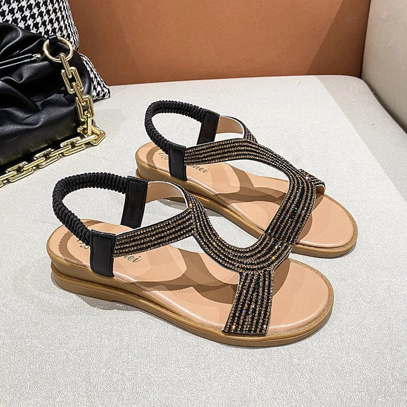 Women's patent leather sandals with rhinestone decoration on round toe shape, shown in gold colour