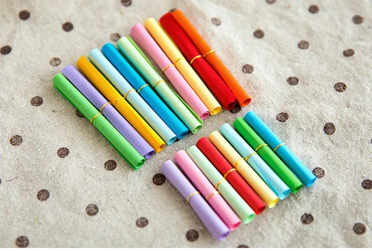 Multi-coloured mini paper scrolls with metal eyelets in 3x7cm, 4x7cm, 5x5cm, and 7x7cm sizes for drift bottle messages