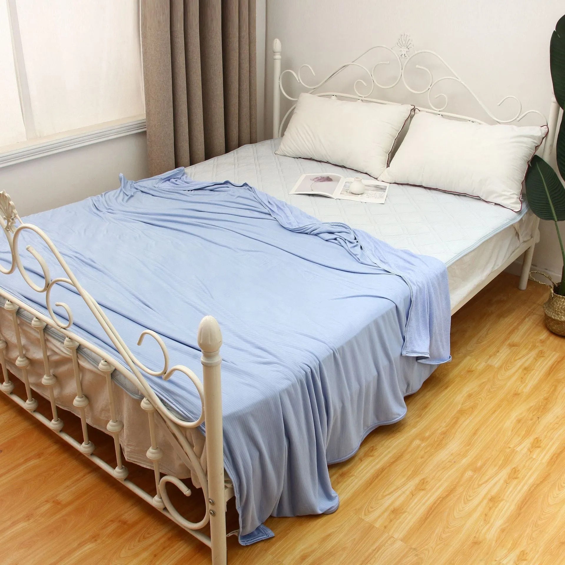 Blue Japanese cooling blanket with Q-Max fibres laid flat on a bed.