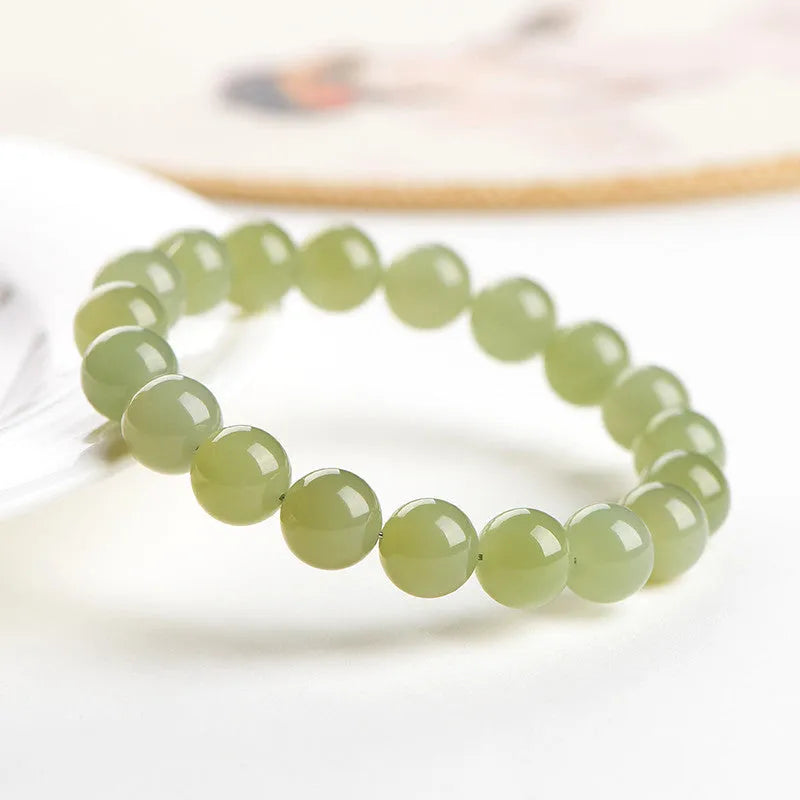 Hetian jade ball bracelet with polished spherical beads on a string, shown in deep and light clear water colour options.