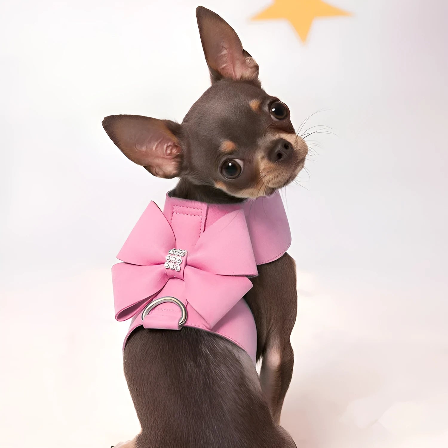 Soft pink microfiber puppy chest strap with a large white bowknot decoration laid flat.
