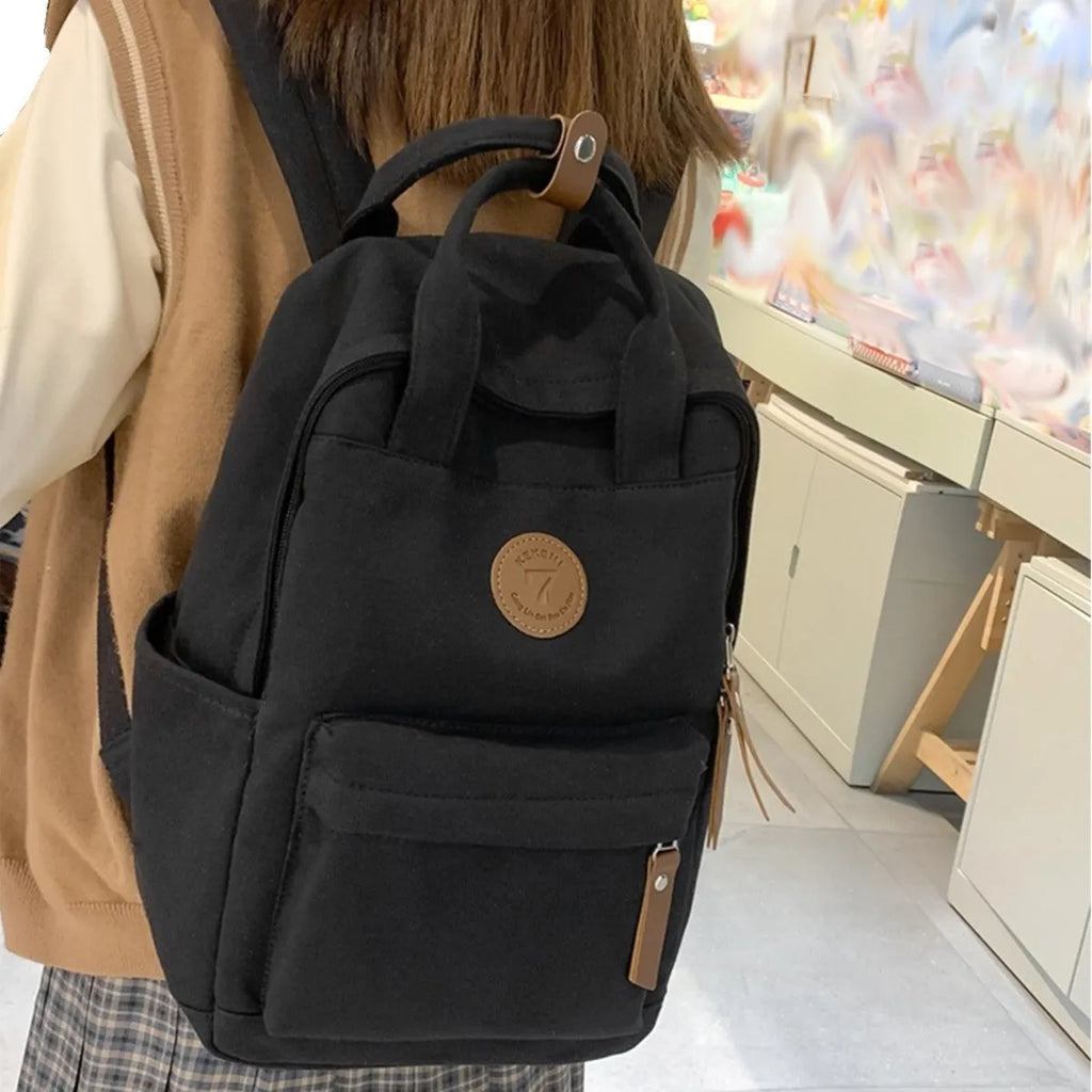 Black Oxford cloth backpack with curved shoulder straps and retro sewing thread accents