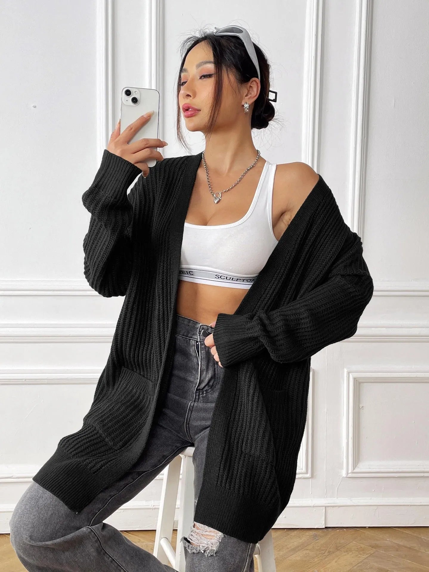 Women's dark green double pocket cardigan with long sleeves and loose fit.